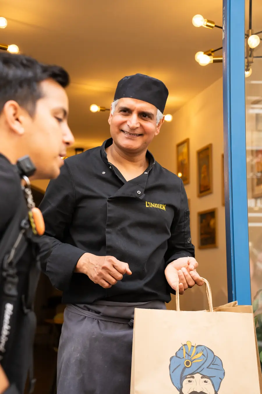 Le chef de L'Indien remet un sac à un livreur Blackbird